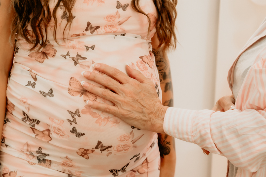 6G4A5311 Heartwarming moment of grandma putting her hand on expectant momma's belly.